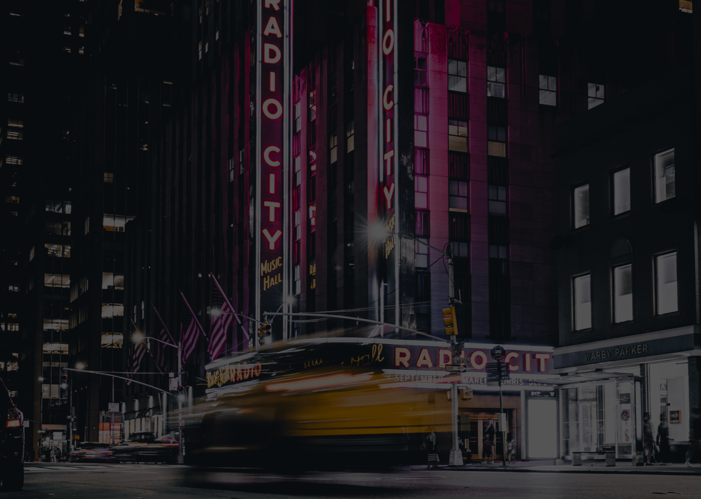 taxi driving past radio city in nyc